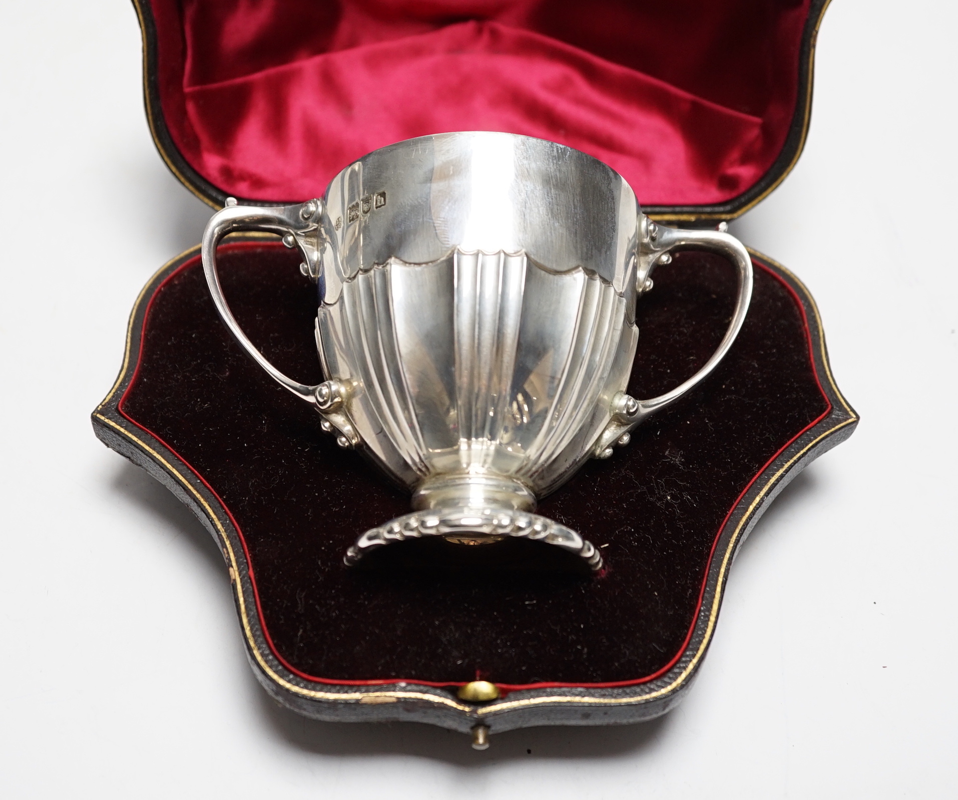 A cased Edwardian silver two handled christening cup, with engraved inscription, Wakely & Wheeler, London, 1903, height 88mm, 6.9oz.